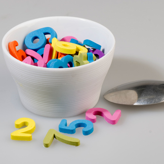 Letras coloridas em recipiente, com colher ao lado