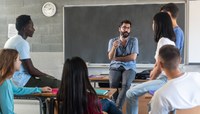 Professor conversa com alunos jovens em sala de aula