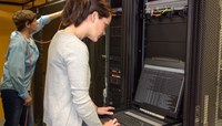 Duas mulheres profissionais atuam na programação e configuração de um data center.