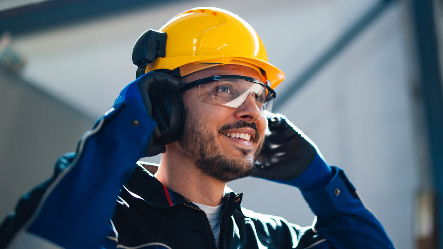 Homem vestindo EPI sorri