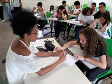 A monitora Lorena Barbosa auxilia os estudantes durante a oficina